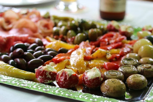 Various antipasti on a silver-colored tray on a table — Stock Photo, Image