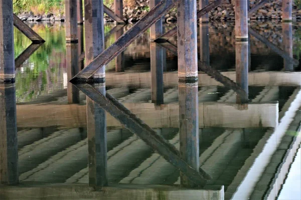 Muelles del puente y su reflejo en el agua — Foto de Stock