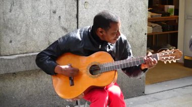 MADRID, İspanya - 25 Mart 2018: Bilinmeyen müzisyen gitar çalıyor ve Fuencarral Caddesi 'nde şarkı söylüyor.
