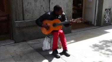 MADRID, İspanya - 25 Mart 2018: Bilinmeyen müzisyen gitar çalıyor ve Fuencarral Caddesi 'nde şarkı söylüyor.