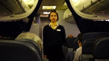 KIEV, UKRAINE - 23 Mart 2018: Boryspil Uluslararası Havaalanı. Hostes, yolculardan önce personel güvenliği bildirimi yapar..