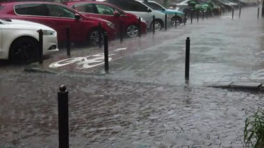 Şehirde yağmur yağıyor. Kaldırıma yağmur damlaları düşüyor..