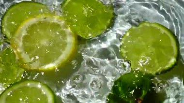 Limon ve limon dilimlerinin düşüşü. Yavaş çekim.