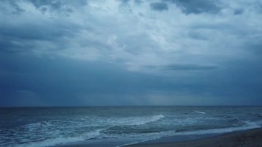 Deniz sahili ve denizin üzerindeki fırtına bulutları.
