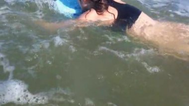 Dalgalarda sörf tahtasında sörf yapan sörfçü kız.