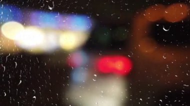 Gece kasabasında bir araba. Yağmur sırasında pencereden görünüm.