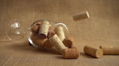 Şarap mantarlarının arka plandaki bardak ve çantalara çarpması. Yavaş çekim.