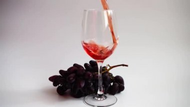 Beyaz arka planda bir bardağa şarap dökmek.