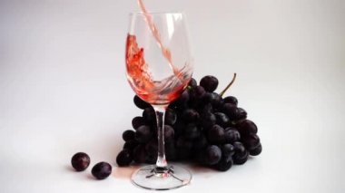 Beyaz arka planda bir bardağa şarap dökmek.