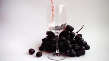 Beyaz arka planda bir bardağa şarap dökmek.