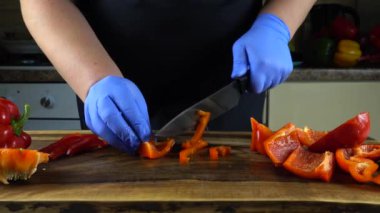 Aşçı kesme tahtasında tatlı biber keser..