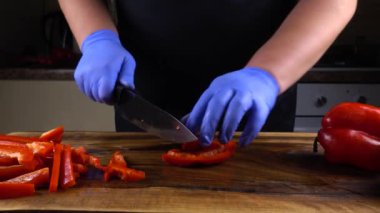 Aşçı kesme tahtasında tatlı biber keser..