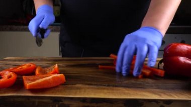 Aşçı kesme tahtasında tatlı biber keser..