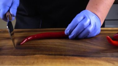 Aşçı acı biberi kesme tahtasıyla keser..