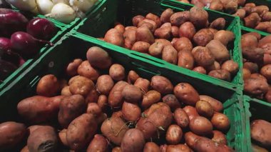 Süpermarkette plastik kutularda soğan, patates ve kabak..