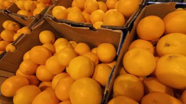 Süpermarkette karton kutulardaki portakallar.