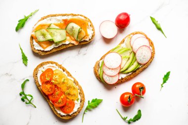 Kahvaltı, atıştırmalık, aperatif, avokado, turp, domates, pastırma, salatalık, krem peynir, tam tahıllı sandviç. Hafif bir arkaplanda