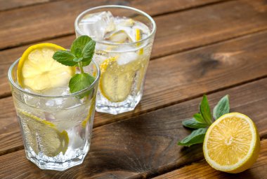 İki bardak limonata ya da limonlu mojito kokteyli, nane ve buz kırsal ahşap arka planda.