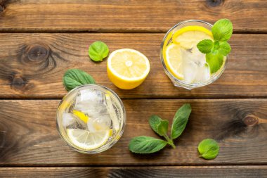 İki bardak limonata ya da limonlu mojito kokteyli, nane ve buz kırsal ahşap arka planda. Üst görünüm, boşluk kopyala