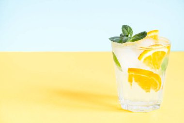 Portakal, nane ve buzlu limonata ile sarı arka planda fotokopi alanı