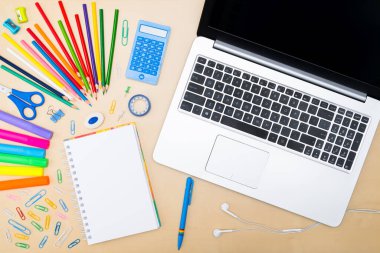 Okul konseptine geri dönelim. Tahta bir öğrenci masasında üst düzey okul malzemeleri. Düz yat ve boşluğu kopyala