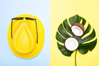 Yaz tatili kavramı. Sarı ve mavi arka planda üst katman canavar görünümlü şapka ve hindistan cevizi. düz yat