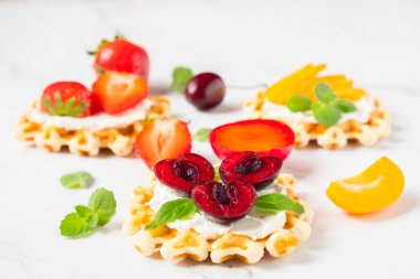 Yumuşak peynirli geleneksel Belçika wafflelarının üst görüntüsü, kopyalama alanı olan meyveler ve meyveler