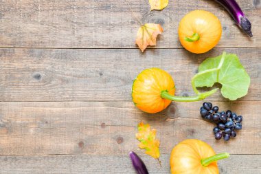 Yapraklar ve sebzelerle sonbahar arkaplanı. Fotokopi alanı ile eski ahşap üzerine sonbahar hasadı. Üst görünüm ve düz uzanma
