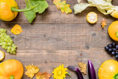 Sarı yapraklar ve sebzelerle sonbahar arkaplanı. Sonbahar hasadının kopyalanmış ahşap üzerindeki çerçevesi. Üst görünüm ve düz uzanma