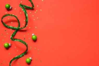 Yeni yıl ya da Noel kompozisyonu 2021. Üst görünüm Xmas dekoratif kırmızı arka plan yeşil süslemeli ve noel süslemeleri fotokopi alanı ile. Tebrik kartı maketi. Düz yatıyordu