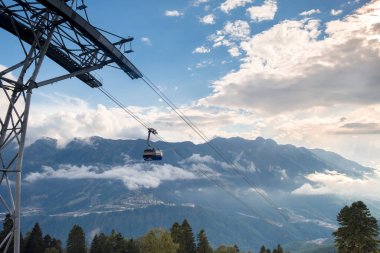 Gazprom, Krasnaya Polyana, Sochi, Rusya - 09 Eylül 2020: Günbatımında bir dağ manzarasının arka planına karşı teleferik.