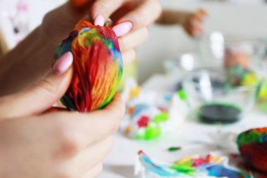 Paskalya için bir yumurtayı peçeteye sar ve resim yap. Sen evde otururken el yapımı soyut resim, rahat bir ev, sanat terapisi, bulanık arka plan.