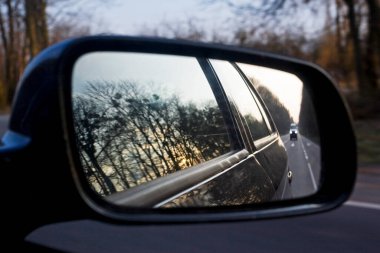 Aynanın içinde, gece yolunda bir arabanın ön camından geçiyor.