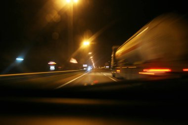Gece şoför, gece yol bir arabanın ön camından geçiyor.