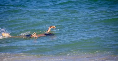 Mutlu çocuk suyun altında yüzüyor, dikey format.