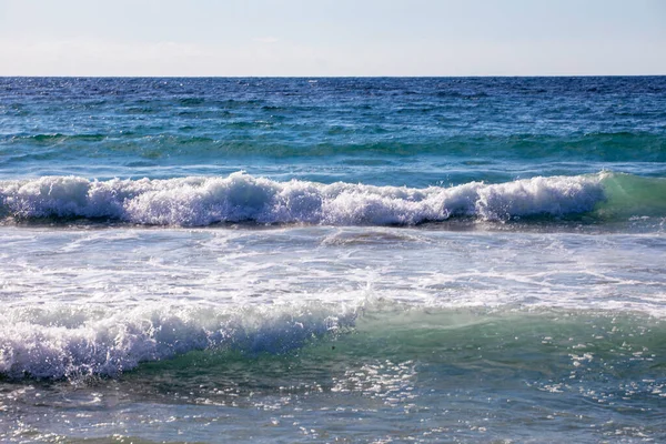 stock image Aegean Sea by day in storm, resort, foam, against sun