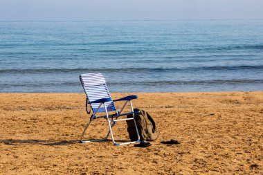 Sabahları boş bir kumsalda sırt çantasıyla boş bir güneş panelini katlıyor. Tatil ve yalnızlık