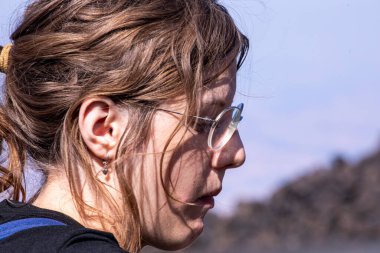 Genç bir kız dağın tepesinde dinleniyor. Aktif aile eğlencesi. okul tatili