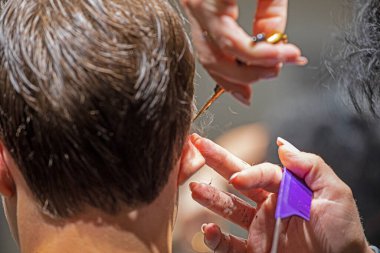 Kuaför saçlarını kulaklarının arkasında keser ve şekil verir.