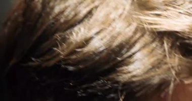 Kuaför, dalgalı saçlar için seyreltici makas ile saç kesimini tamamlıyor.