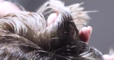 Kuaför saç kesimini seyrelten makasla tamamlar ve gelecek için kısa saç kesiminde dalgalar yaratır.