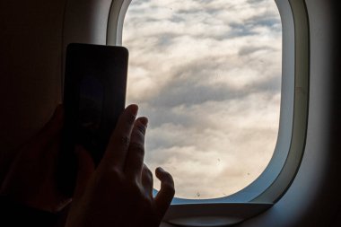 Uçaktaki bir pencereden bulutları fotoğraflamak
