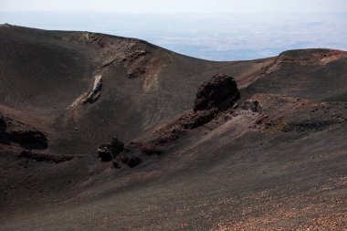 huge crater with volcanic rocks on Mount Etna. Traveling in Italy