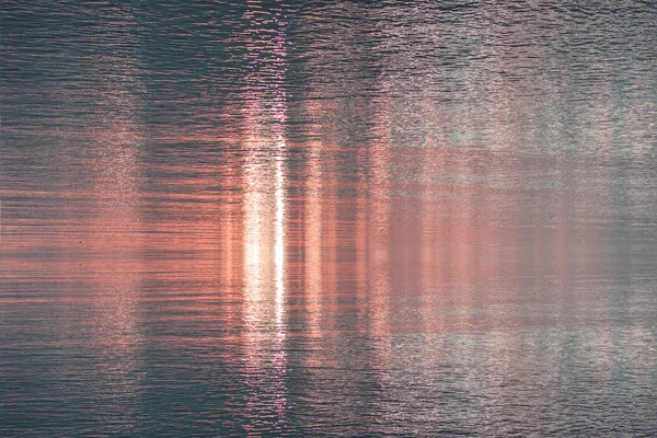 Superficie de agua con fondo texturizado reflejo del atardecer — Foto de Stock