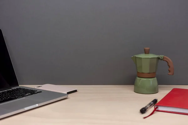 Dizüstü bilgisayarı ve İtalyan kahve makinesi olan çalışma masası.