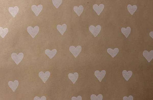 Ambachtelijke bruin papier met witte harten achtergrond — Stockfoto