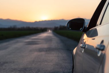 akşam yolu arabadan gün batımı görünümüne başlığı