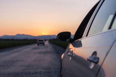 akşam yolu arabadan gün batımı görünümüne başlığı