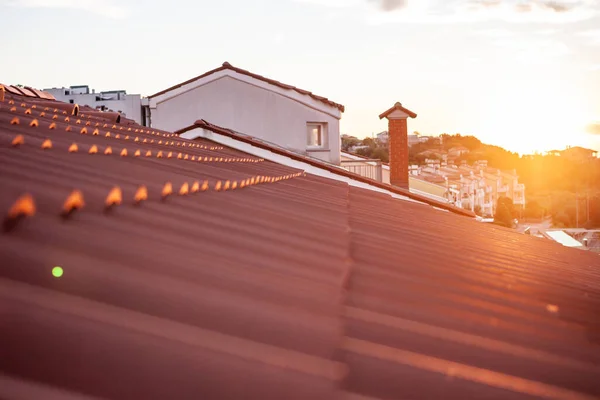 Zachód słońca nad zbliżeniem czerwony dach dachówki — Zdjęcie stockowe