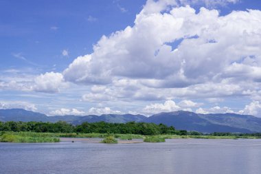 Nehirler ve ormanlar, dağlar ve mavi gökyüzü ve beyaz bulutlar